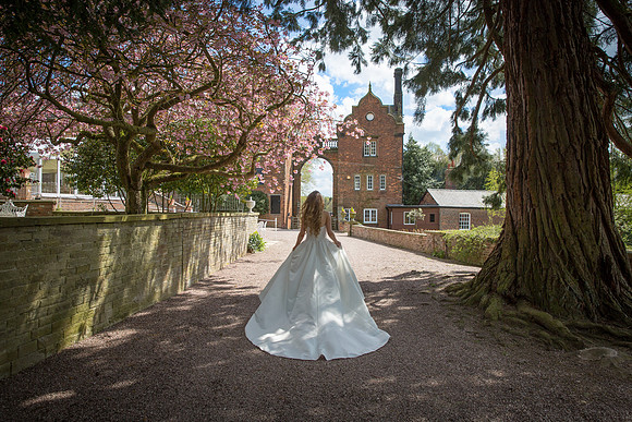 Captivating Entrance: Bride's Dramatic Walk at Capesthorne Hall Archway